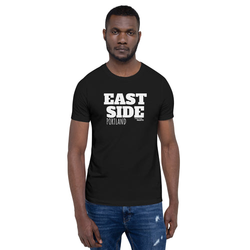 A man wearing a black short-sleeve t-shirt with 'EAST SIDE PORTLAND' printed in bold white text on the chest, paired with blue jeans, set against a plain white background.